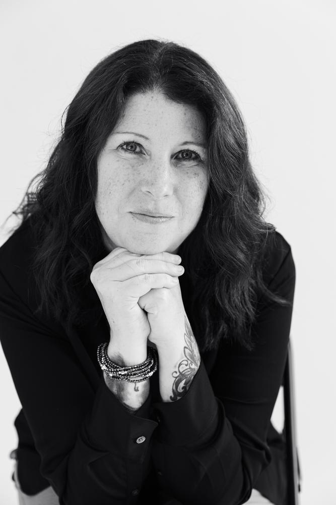 Black and white portrait of a woman with hands under her chin