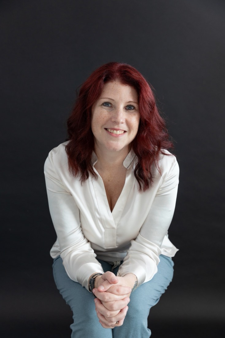 Studio headshot of a smiling woman in a white blouse against a dark grey backdrop, Southwest Florida personal branding photographer