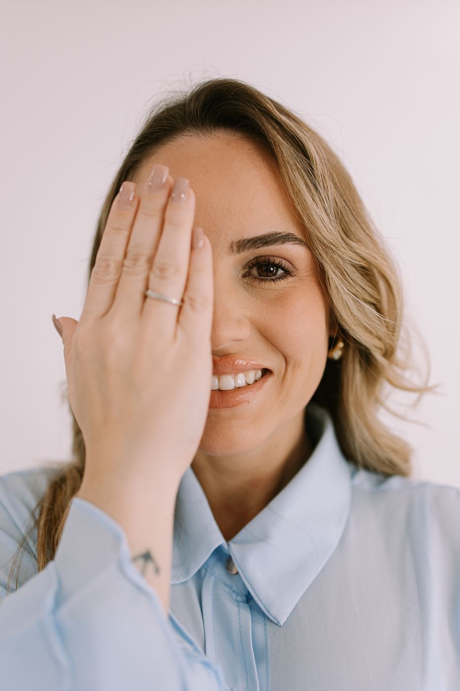 Playful branding portrait — professional covering one eye and laughing, Cape Coral studio