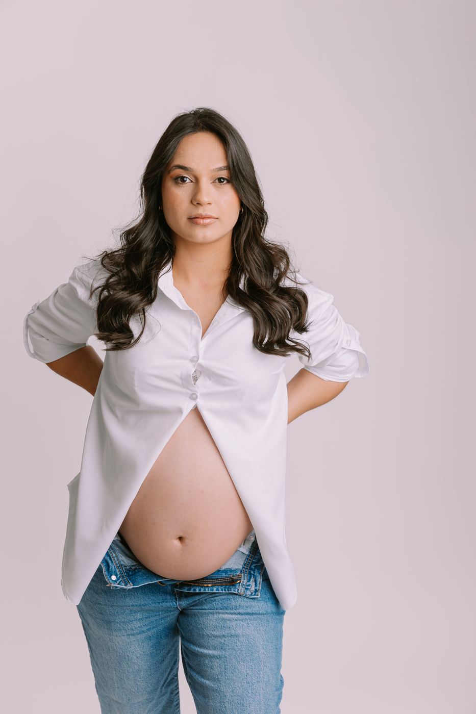 Expecting mother in white shirt and jeans photographed in the Cape Coral studio by maternity photographer Ana Rousseau