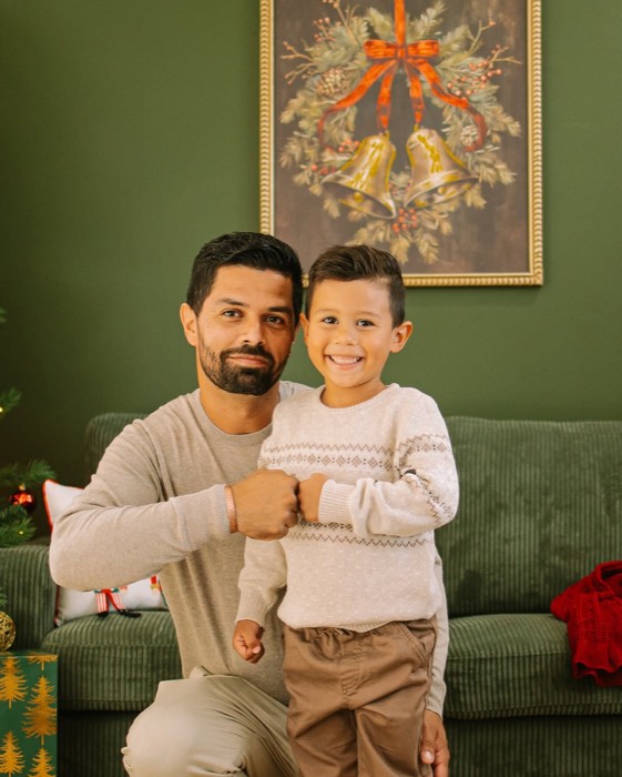 Father and son in front of the holiday wreath at the studio