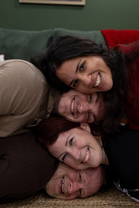 Whole family piled cheek-to-cheek for a close-up on the couch